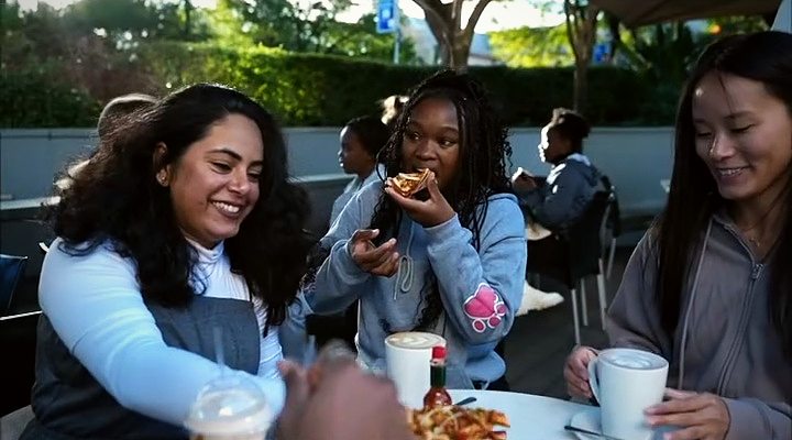 Friends sharing food and coffee at an outdoor table