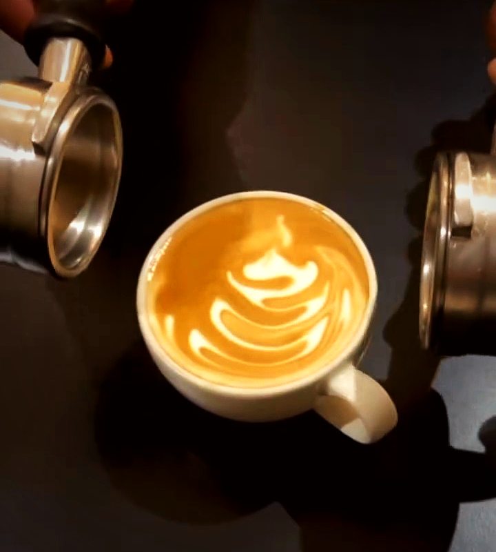 A barista pouring latte art