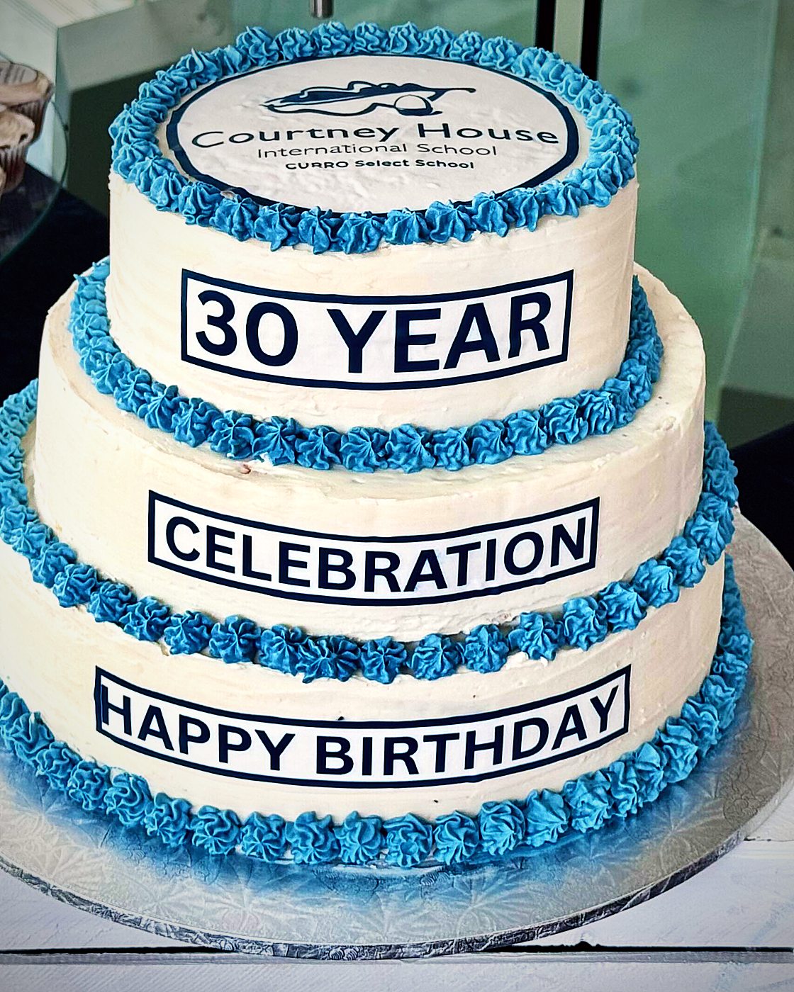 A three-tier celebration cake in blue and white