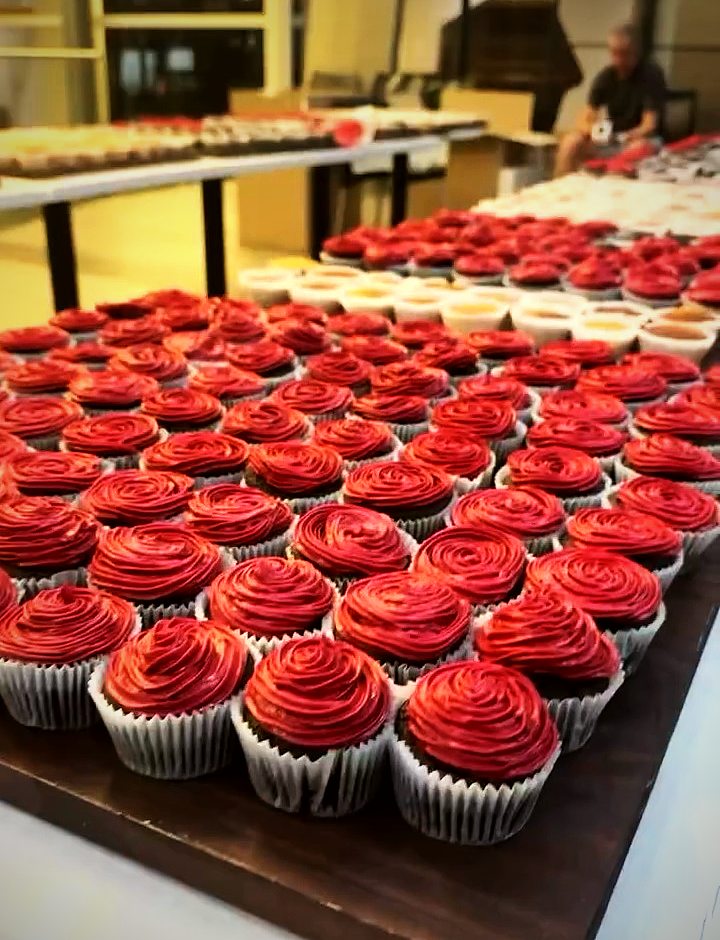 Trays of red velvet cupcakes with swirled frosting