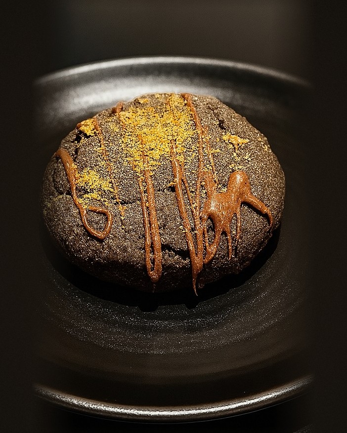 A double chocolate cookie drizzled with caramel and dusted with gold