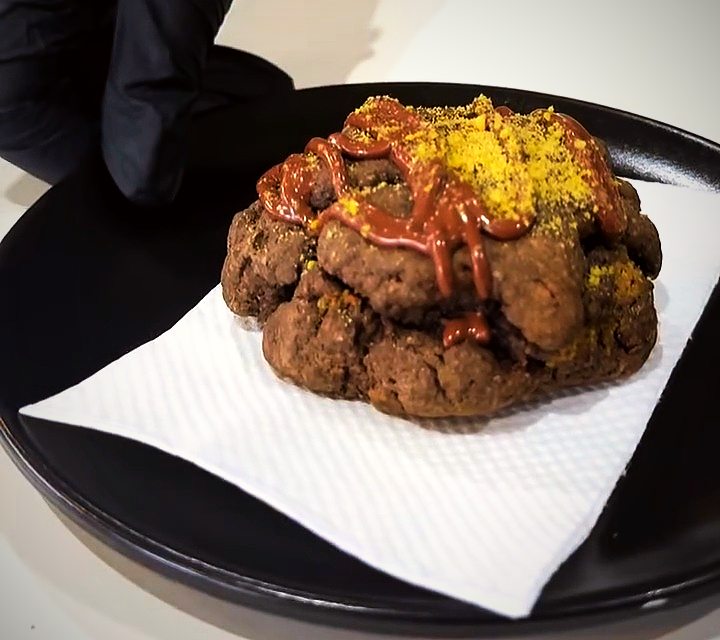 A Dubai chocolate cookie with pistachio and chocolate drizzle