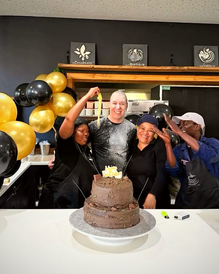 The kitchen team celebrating around a chocolate cake
